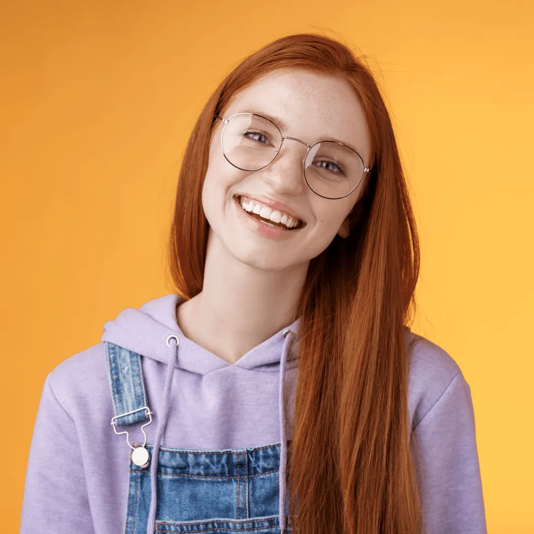 Smiling woman with glasses in a denim overall, representing fresh ingredient sourcing